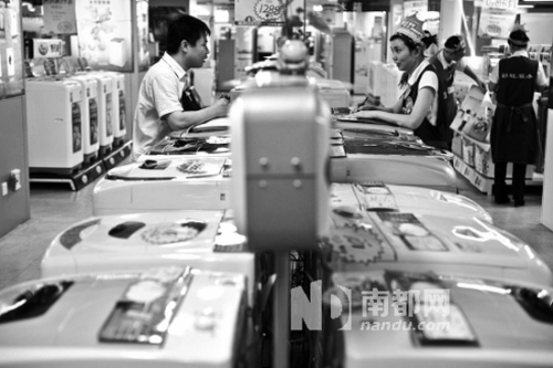 顾客和卖场工作人员讨论家电价