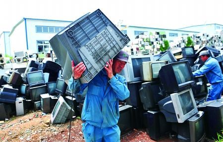 一废旧家电处理厂，工人将废旧电视机搬运至车间进行处理。 新华社 图