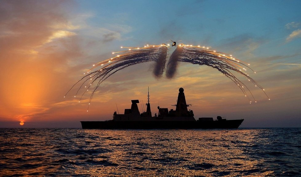 地中海上，英国皇家海军45型勇敢级导弹驱逐舰“龙”号上的山猫HMA 8型直升机正在驱逐舰上空释放信号弹。