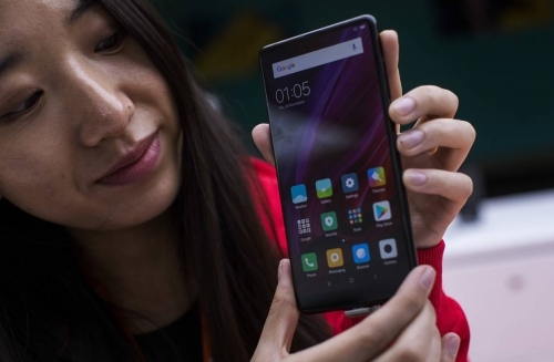 A woman shows off the new Xiaomi Mi MIX 2 at a conference in Spain in February. 
