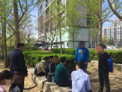 ▲4月11日，乐视大厦东面的树荫下，8名讨债者仍在坚守。