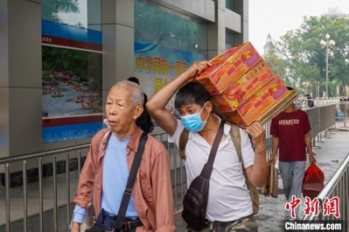 一名男子背着三箱越南商品入境中国。王以照 摄